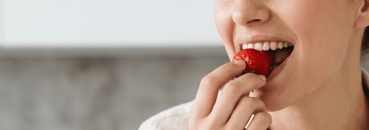 Woman enjoying a fresh strawberry